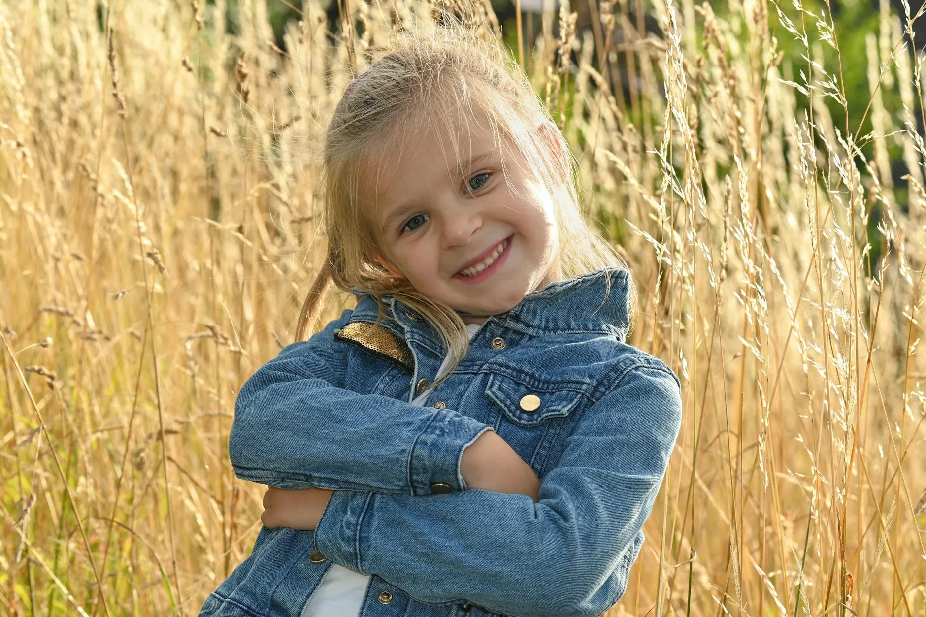 Kind in spijkerjasje in zonnig veld